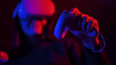 VR gözlük takan genç bir kadın, kırmızı ve mavi ışıklı. Yavaş çekim