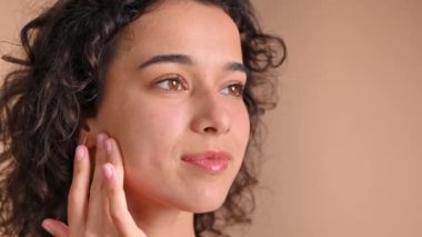 Genç beyaz bir kadın yüz maskesi yapıyor.