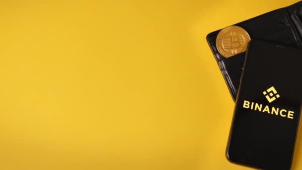 Chisinau Moldova 11月 2022 財布の中の黄金の物理ビットコインとそれにBinanceアプリを搭載した電話 — ストック動画