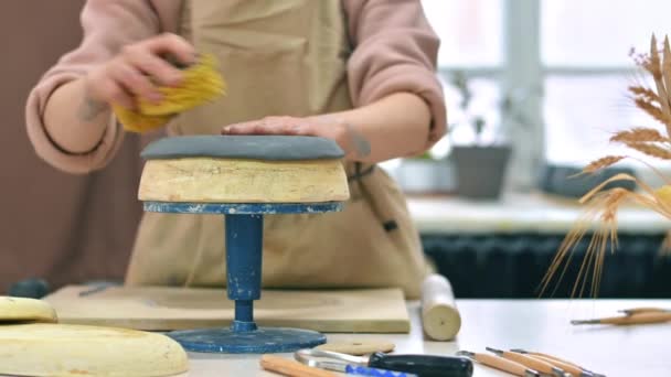 工房で働く陶器の彫刻の達人 丸みを帯びた形を粘土に与えます テーブルの上のツールと材料 — ストック動画