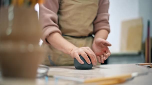 工房で働く陶器の彫刻の達人 彼女の手で粘土の一部を混練 テーブルの上のツール スローモーション — ストック動画