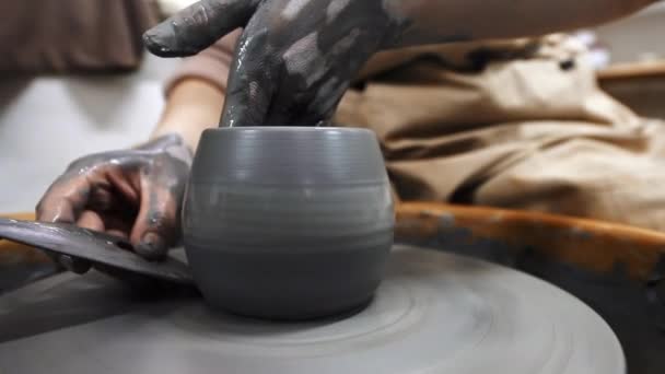스튜디오에서 일하는 조각의 도공의 바퀴에 진흙을 조각하는 도구를 이용해서 말이죠 — 비디오