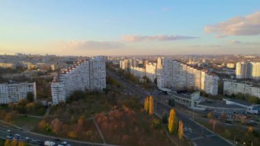 Chisinau 'nun günbatımında Moldova' da hava aracı görüntüsü. Şehrin manzarası. Birden fazla bina ve sararmış ağaçlarla kapılar.