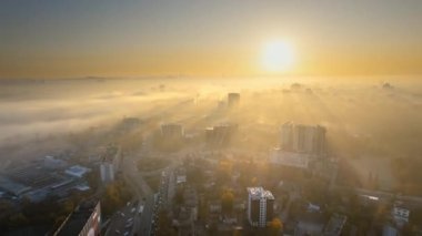 Chisinau 'nun güneş doğarken Moldova' daki hava aracı görüntüsü. Gökyüzünde sis olan şehir manzarası, birden fazla bina, Dendrarium parkı ve sararmış ağaçlı sokaklar.