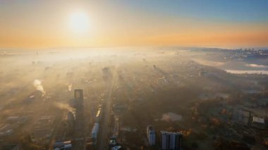 Chisinau 'nun güneş doğarken Moldova' daki hava aracı görüntüsü. Gökyüzünde sis olan şehir manzarası, birden fazla bina, Dendrarium parkı ve sararmış ağaçlı sokaklar.