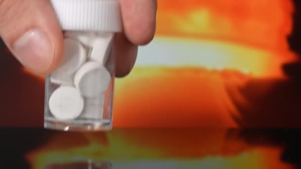 男人把一个装有抗辐射碘药的罐子放在桌上 把核爆炸放在后面 — 图库视频影像