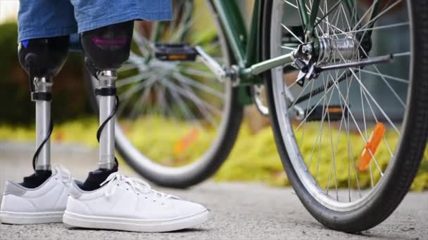 一个假肢男子的慢镜头 把自行车放在脚手架上 站在它旁边 — 图库视频影像