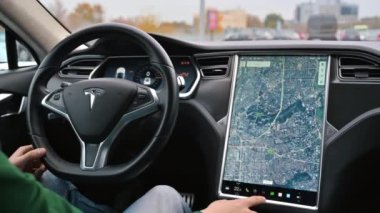 CHISINAU, MOLDOVA - Kasım 2022: bir Tesla S modelinin iç mekanı. Harita ve enerji tüketimi bilgisiyle ana ekranı kullanan sürücü