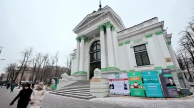 CHISINAU, MOLDOVA - DECEMBER, 2022: Street view of city downtown in winter. Organ Hall with walking people, bare trees on the street