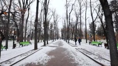 CHISINAU, MOLDOVA - DECEMBER, 2022: View of Stephen the Great Park during a snowfall, walking people, bare trees