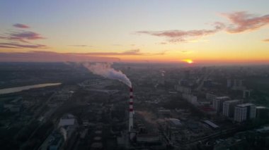 Aerial drone view of thermal power plant in Chisinau at sunrise, Moldova. View of pipe with felling steam, cityscape