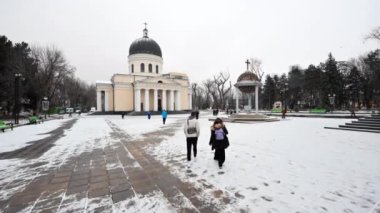 CHISINAU, MOLDOVA - DECEMBER, 2022: View of Central Park in winter, walking people, bare trees, Cathedral