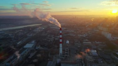 Aerial drone view of thermal power plant in Chisinau at sunrise, Moldova. View of pipe with felling steam, cityscape