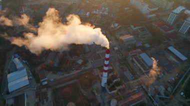 Aerial drone view of thermal power plant in Chisinau at sunrise, Moldova. View of pipe with felling steam, cityscape