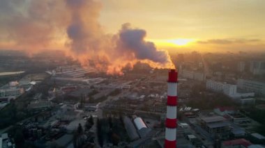 Aerial drone view of thermal power plant in Chisinau at sunrise, Moldova. View of pipe with felling steam, cityscape