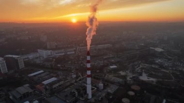 Aerial drone timelapse view of thermal power plant in Chisinau at sunset, Moldova. View of pipe with felling steam, cityscape