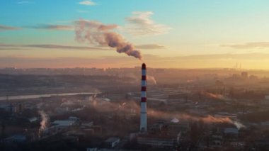 Aerial drone view of thermal power plant in Chisinau at sunrise, Moldova. View of pipe with felling steam, cityscape