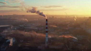 Aerial drone view of thermal power plant in Chisinau at sunrise, Moldova. View of pipe with felling steam, cityscape