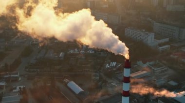 Aerial drone view of thermal power plant in Chisinau at sunrise, Moldova. View of pipe with felling steam, cityscape