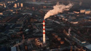 Aerial drone view of thermal power plant in Chisinau at sunrise, Moldova. View of pipe with felling steam, cityscape