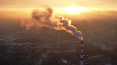 Aerial drone view of thermal power plant in Chisinau at sunrise, Moldova. View of pipe with felling steam, cityscape
