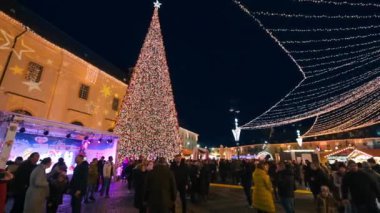 ROMANIA, SIBIU - DECEMBER, 2022: View of the Historic Centre of the town with Christmas fair. The Great Square decorated with Christmas Tree, illumination, old buildings and multiple people