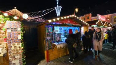 ROMANIA, SIBIU - DECEMBER, 2022: View of the Historic Centre of the town with Christmas fair. The Great Square decorated with illumination, multiple people and shops