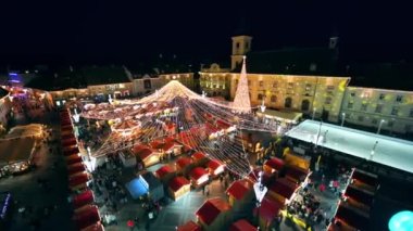 ROMANIA, SIBIU - DECEMBER, 2022: Aerial view of the Historic Centre of the town with Christmas fair. The Great Square decorated with illumination, multiple people