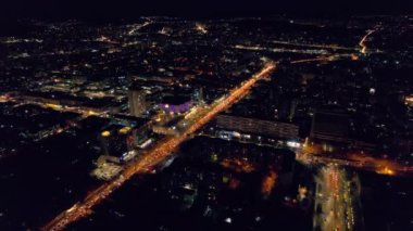 Aerial drone view of Chisinau at night, Moldova. View of city centre with multiple buildings, roads with traffic, illumination