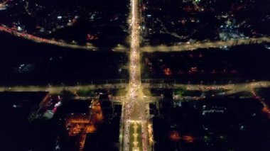 Aerial drone view of Chisinau at sunset, Moldova. View of city centre with multiple buildings, roads with traffic, illumination