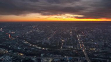 Aerial drone timelapse view of Chisinau at sunset, Moldova. View of the city with multiple buildings, roads with traffic, illumination