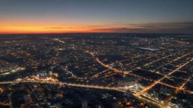 Aerial drone timelapse view of Chisinau at sunset, Moldova. View of the city centre with multiple buildings, roads with traffic, illumination
