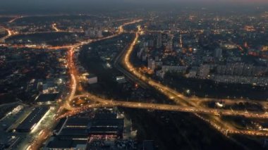 Aerial drone timelapse view of Chisinau at sunset, Moldova. View of the city with multiple buildings, roads with traffic, illumination