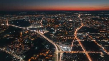 Aerial drone timelapse view of Chisinau at sunset, Moldova. View of the city with multiple buildings, roads with traffic, illumination