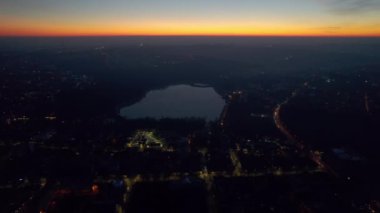 Aerial drone view of Chisinau at sunset, Moldova. View of city centre with lake, buildings, roads, illumination