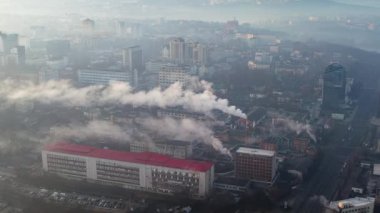 Aerial drone view of an production facility in Chisinau at sunrise, Moldova. Cityscape with multiple buildings, pipes with felling steam