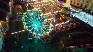 ROMANIA, SIBIU - DECEMBER, 2022: View of the Historic Centre of the town with Christmas fair. The Great Square decorated with ferris wheel, Christmas tree, ice rink, people