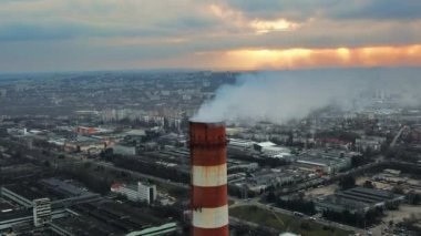 Aerial drone view of thermal power plant in Chisinau at cloudy weather, Moldova. View of pipes with felling steam, cityscape, sunset