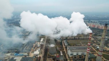 Aerial drone view of thermal power plant in Chisinau at cloudy weather, Moldova. View of pipes with felling steam, cityscape