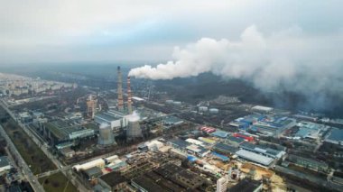 Aerial drone view of thermal power plant in Chisinau at cloudy weather, Moldova. View of pipes with felling steam, cityscape