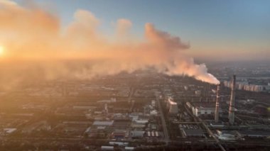 Aerial drone timelapse view of thermal power plant in Chisinau at sunset, Moldova. View of pipes with felling steam, cityscape