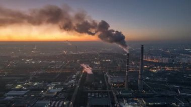 Aerial drone timelapse view of thermal power plant in Chisinau at sunset, Moldova. View of pipes with felling steam, cityscape
