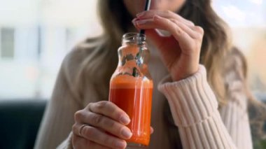 Woman drinking fresh carrot juice at a restaurant