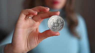 Elinde bitcoin kripto para tutan bir kadın. Yakın plan.