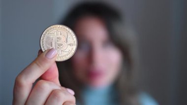 Elinde bitcoin kripto para tutan bir kadın. Yakın plan.
