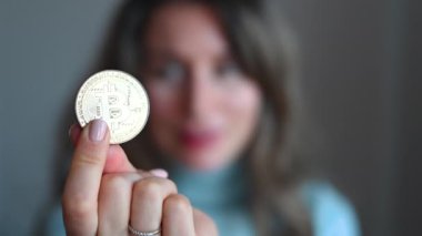 Elinde bitcoin kripto para tutan bir kadın. Yakın plan.