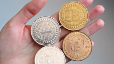 Altın ve gümüş Bitcoin kripto paralarını tutan kadın elleri