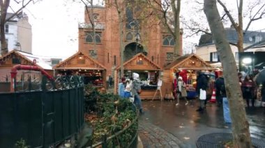 PARIS, FRANCE - JANUARY, 2022: Street view of the city. Square with multiple shops, walking people, cloudy weather