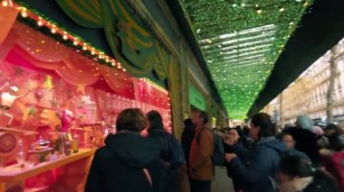 PARIS, FRANCE - DECEMBER, 2022: Street view of city downtown. Illumination, walking people, showcase with moving toys