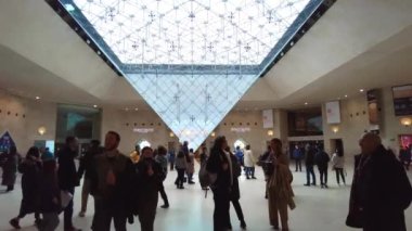 PARIS, FRANCE - DECEMBER, 2022: View of the Inverted pyramid at the underground entrance to the Louvre Museum, multiple people